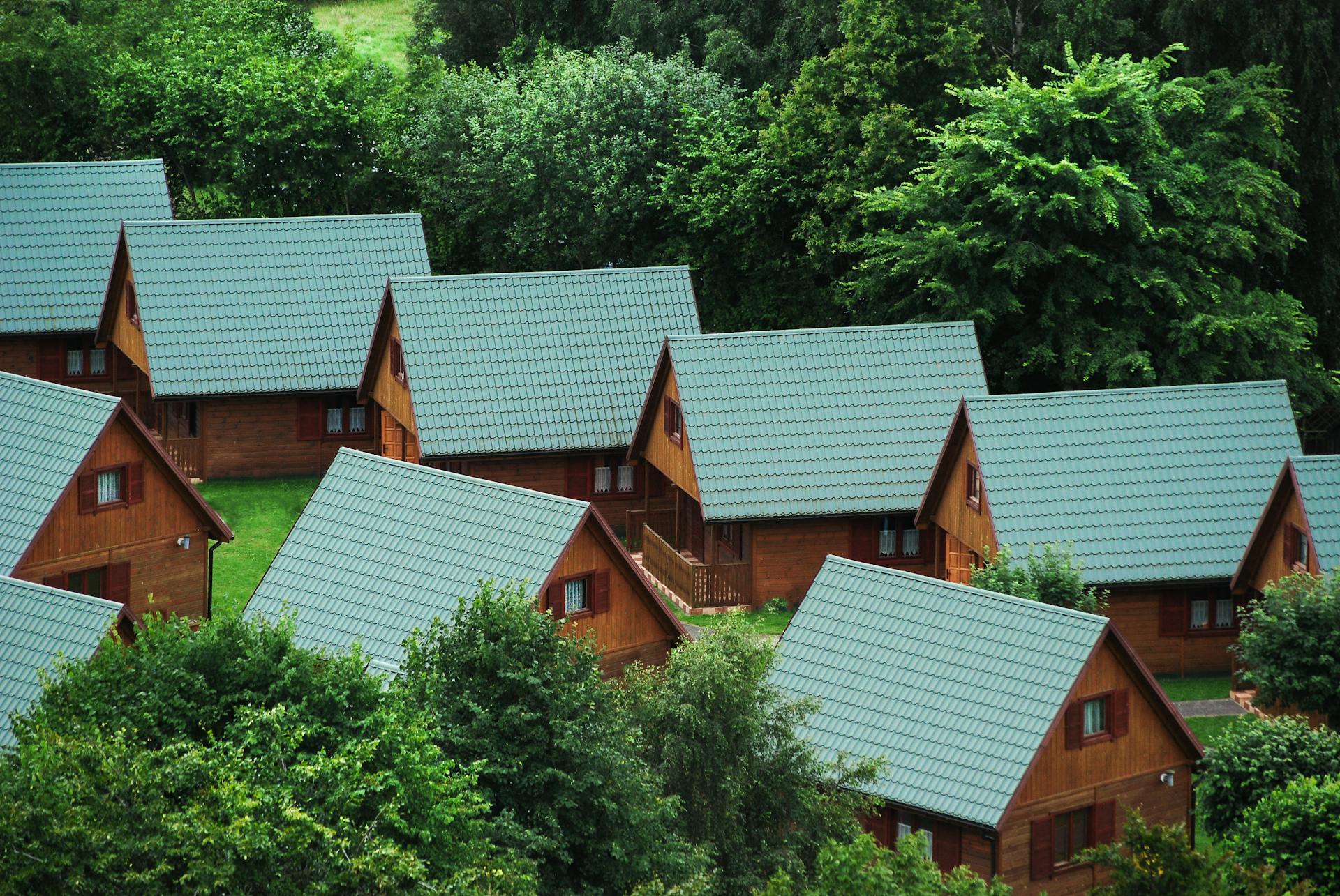 Picturesque wooden cabins nestled among trees, showcasing rustic architecture and serene nature.